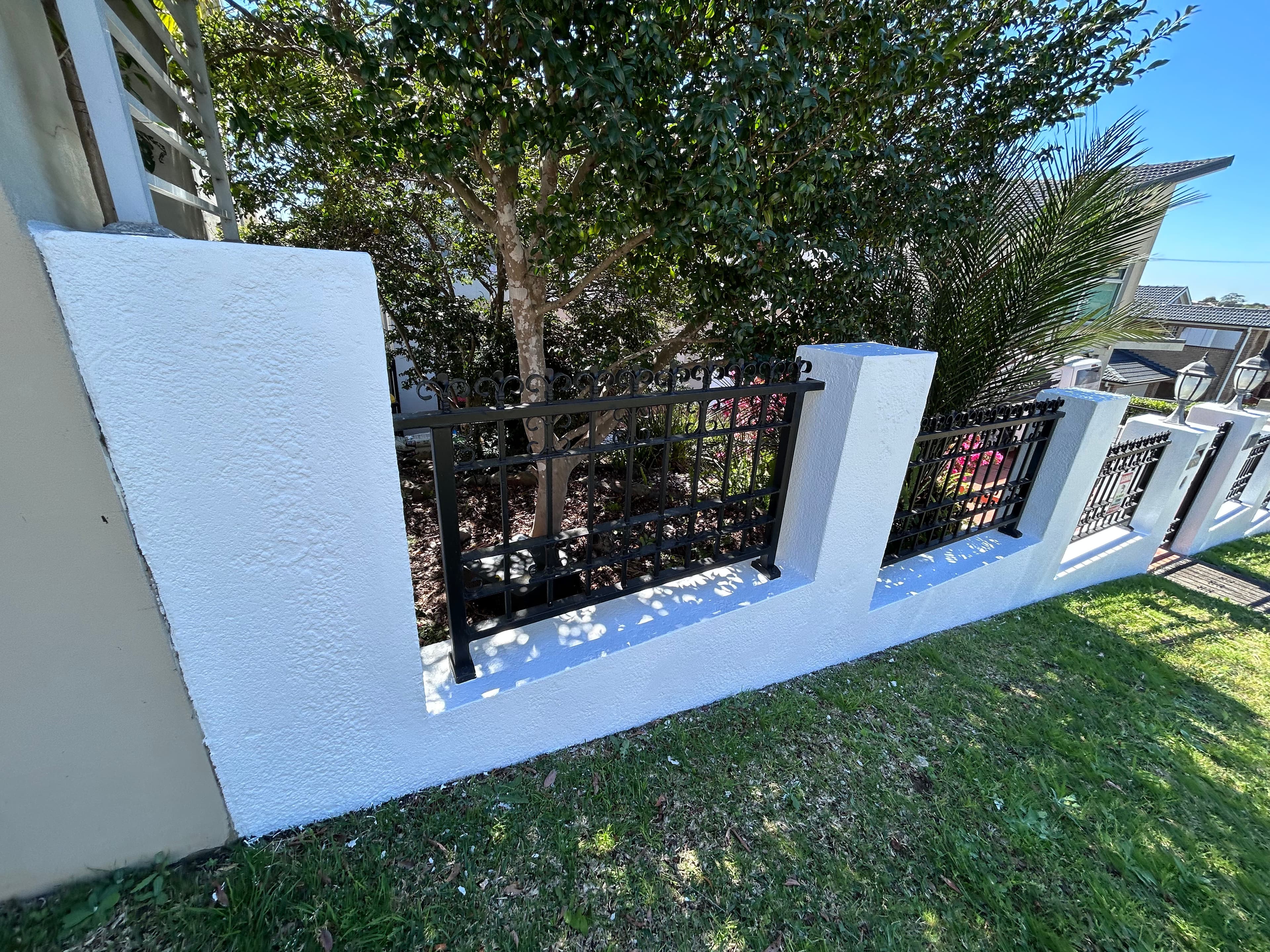 The same street-side concrete fence after repainting in Blakehurst