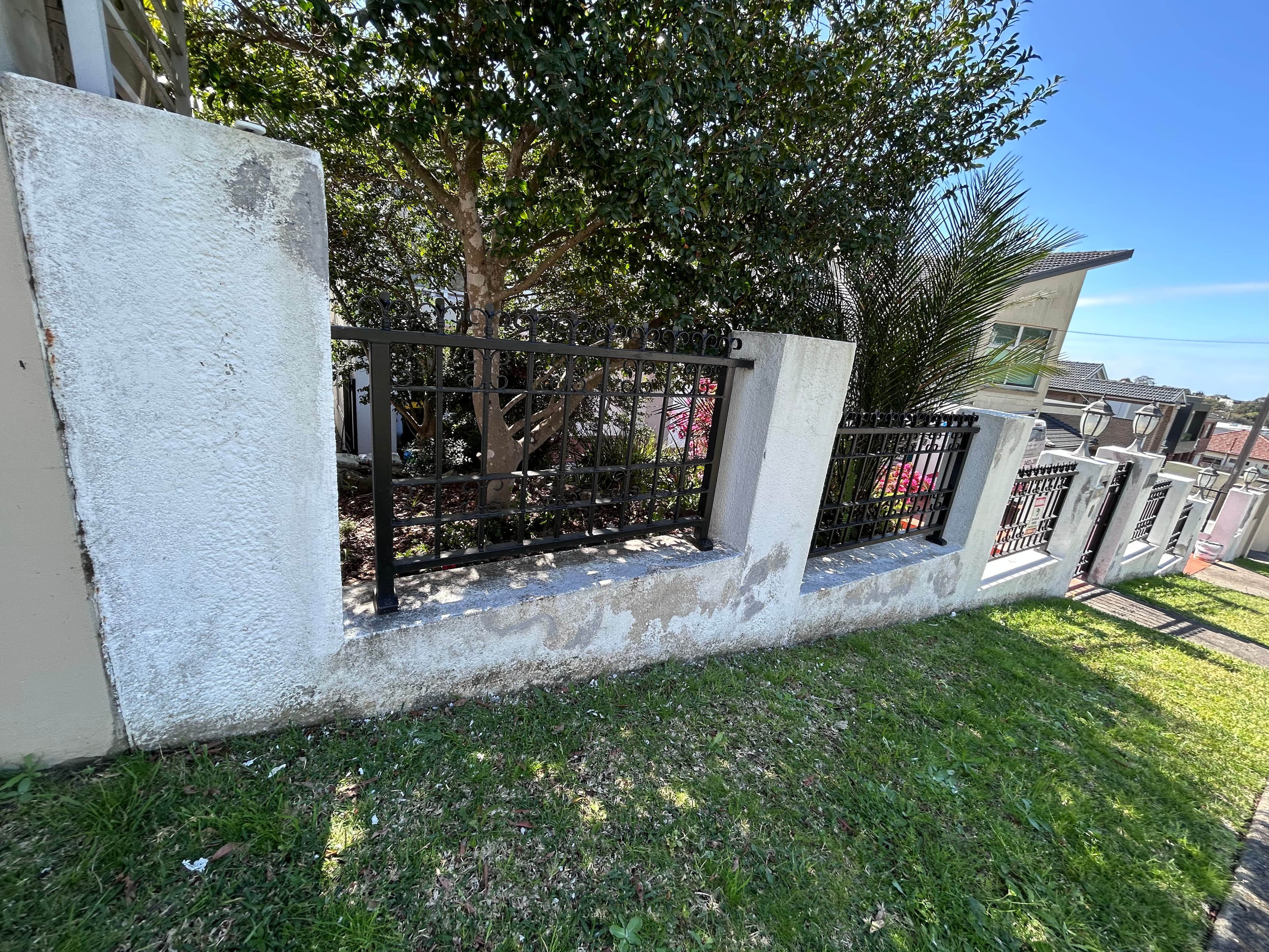 Street-side concrete fence before repainting in Blakehurst