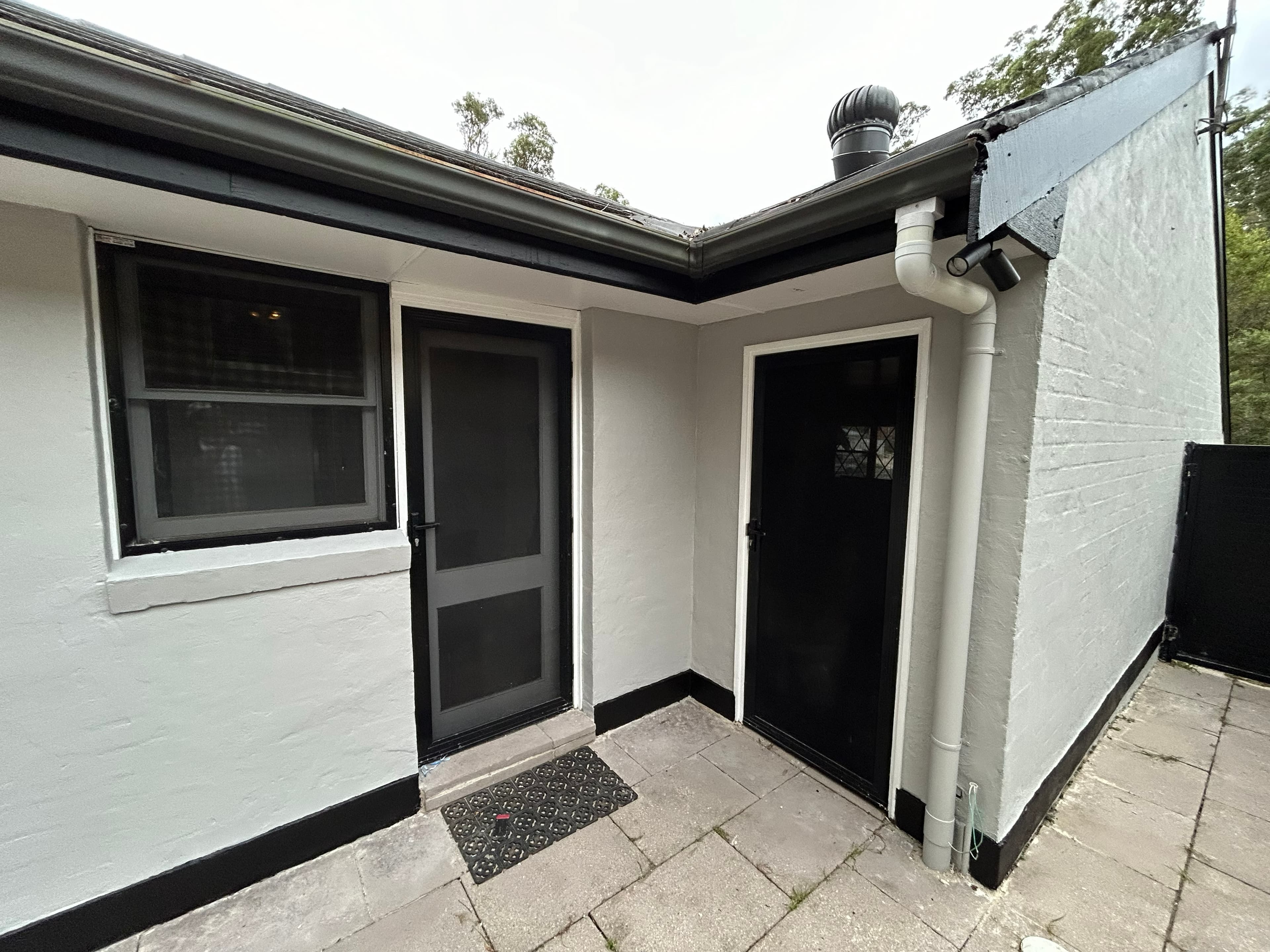 Carlingford entry corner after repainting with black doors and white exterior walls