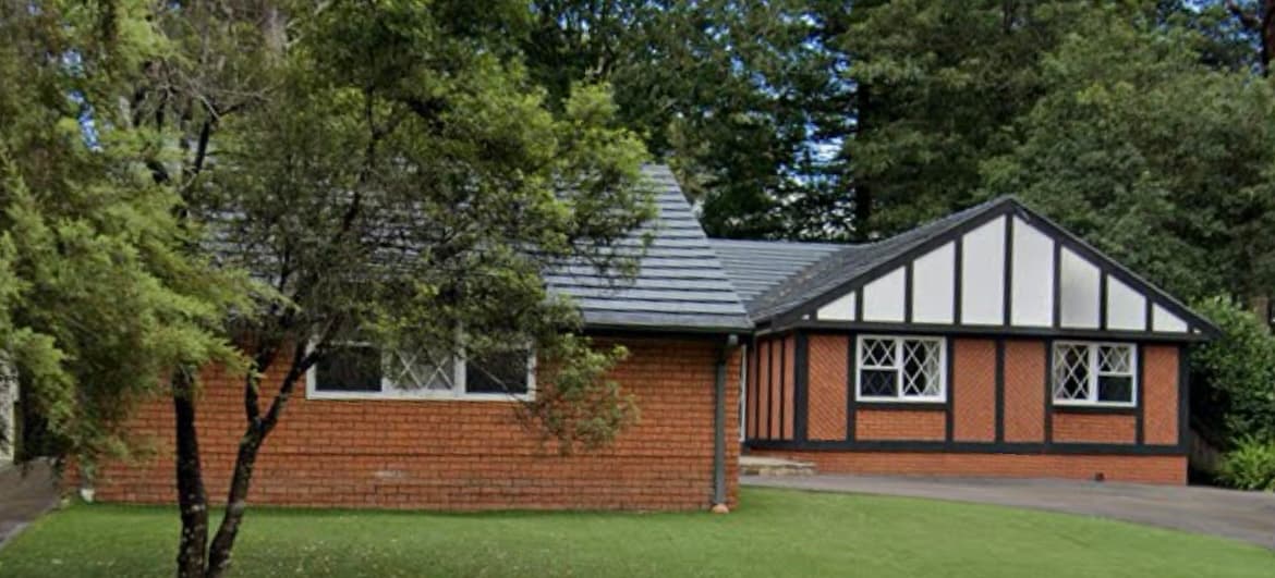 Carlingford house exterior before repainting with brick facade and dark trim