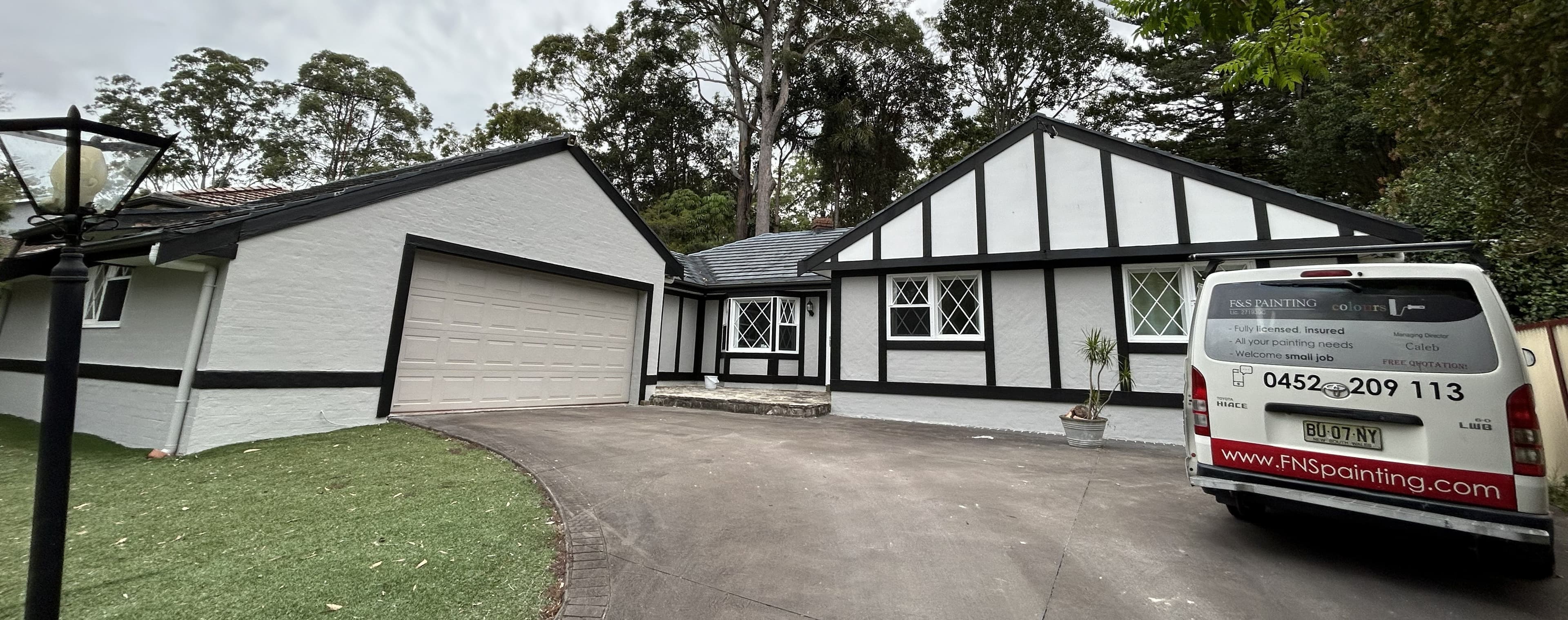Carlingford house exterior with freshly painted white walls, black trim, and garage facade