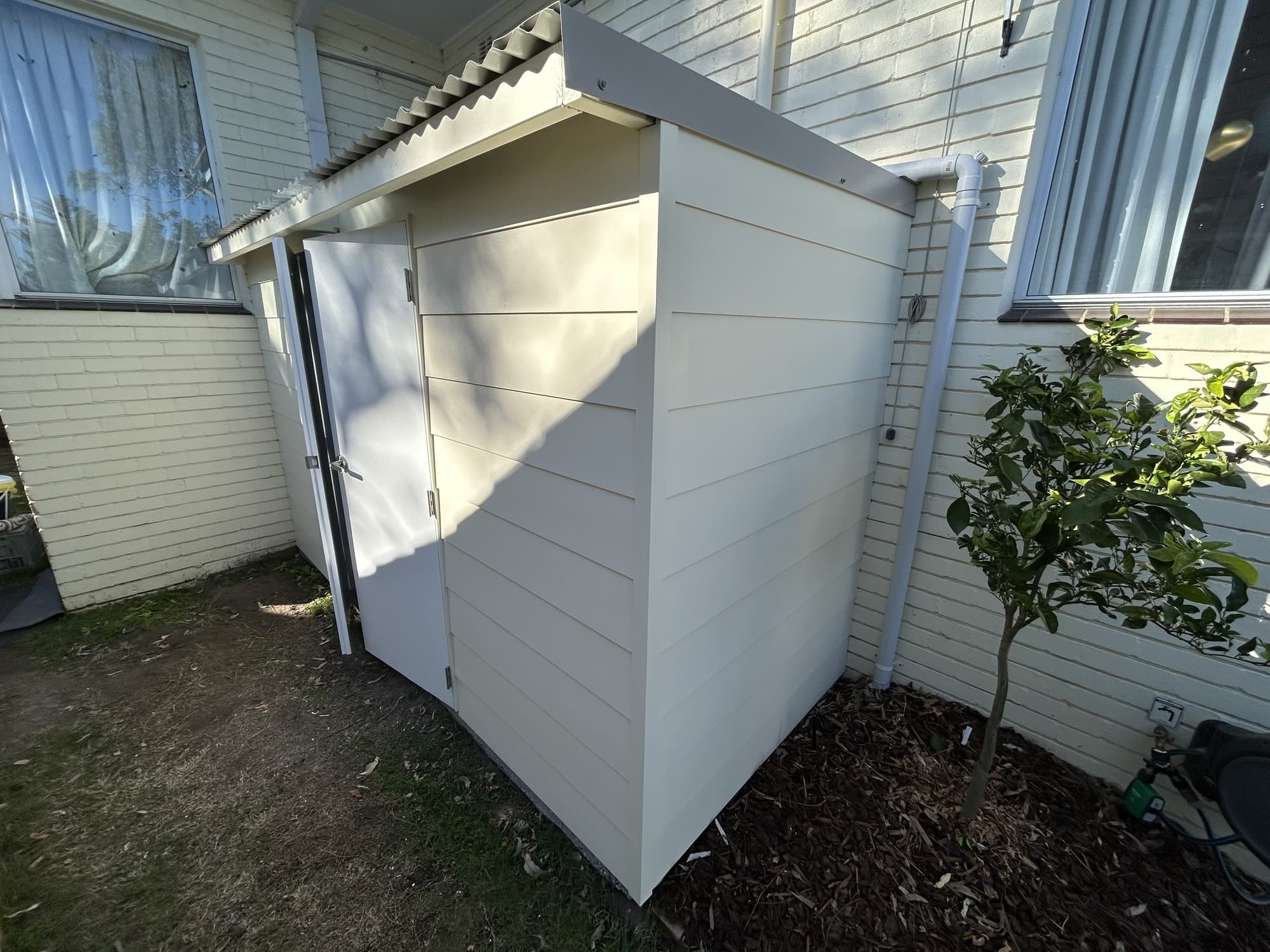 Garden shed exterior and doors after repainting with a clean light finish in Chatswood West