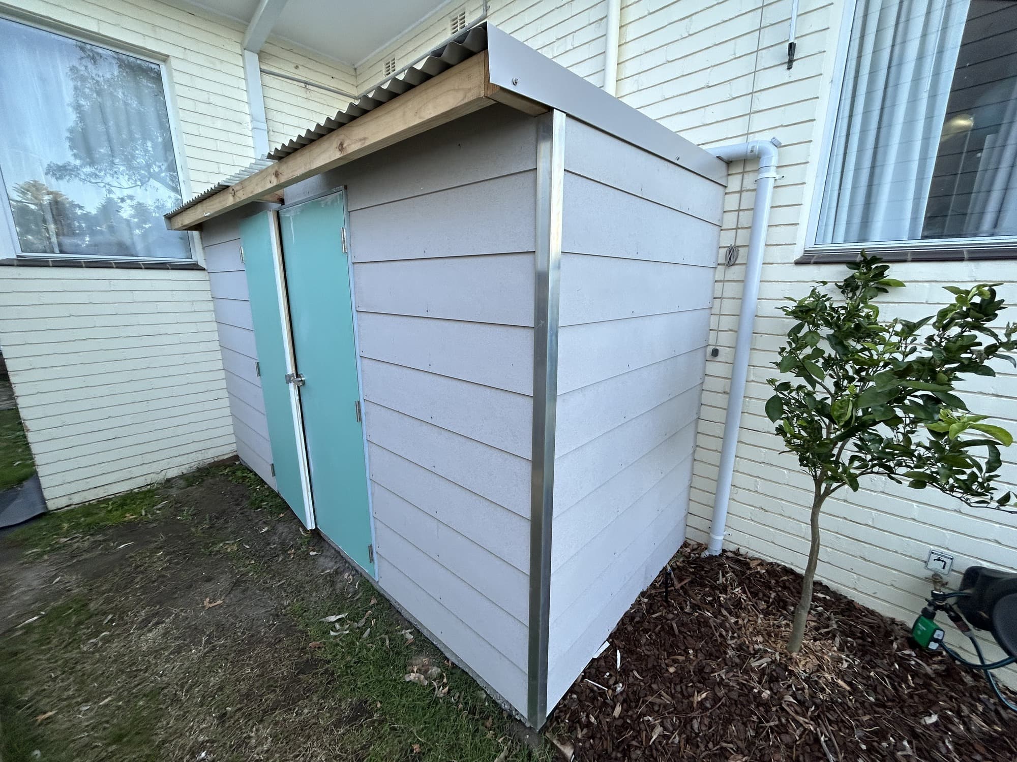 Grey garden shed exterior and contrasting doors before painting in Chatswood West