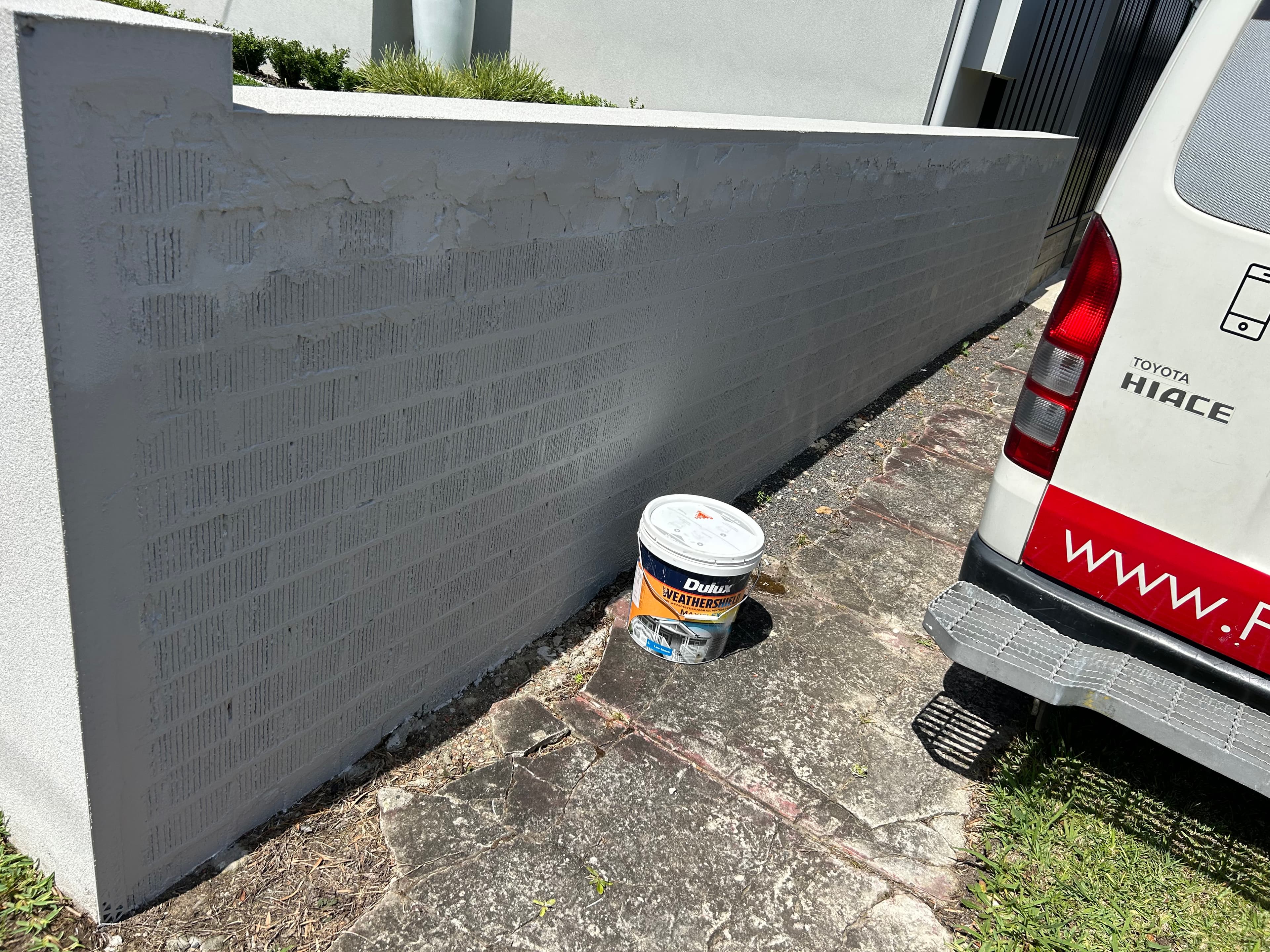 Boundary wall after exterior painting with grey weather-resistant coating