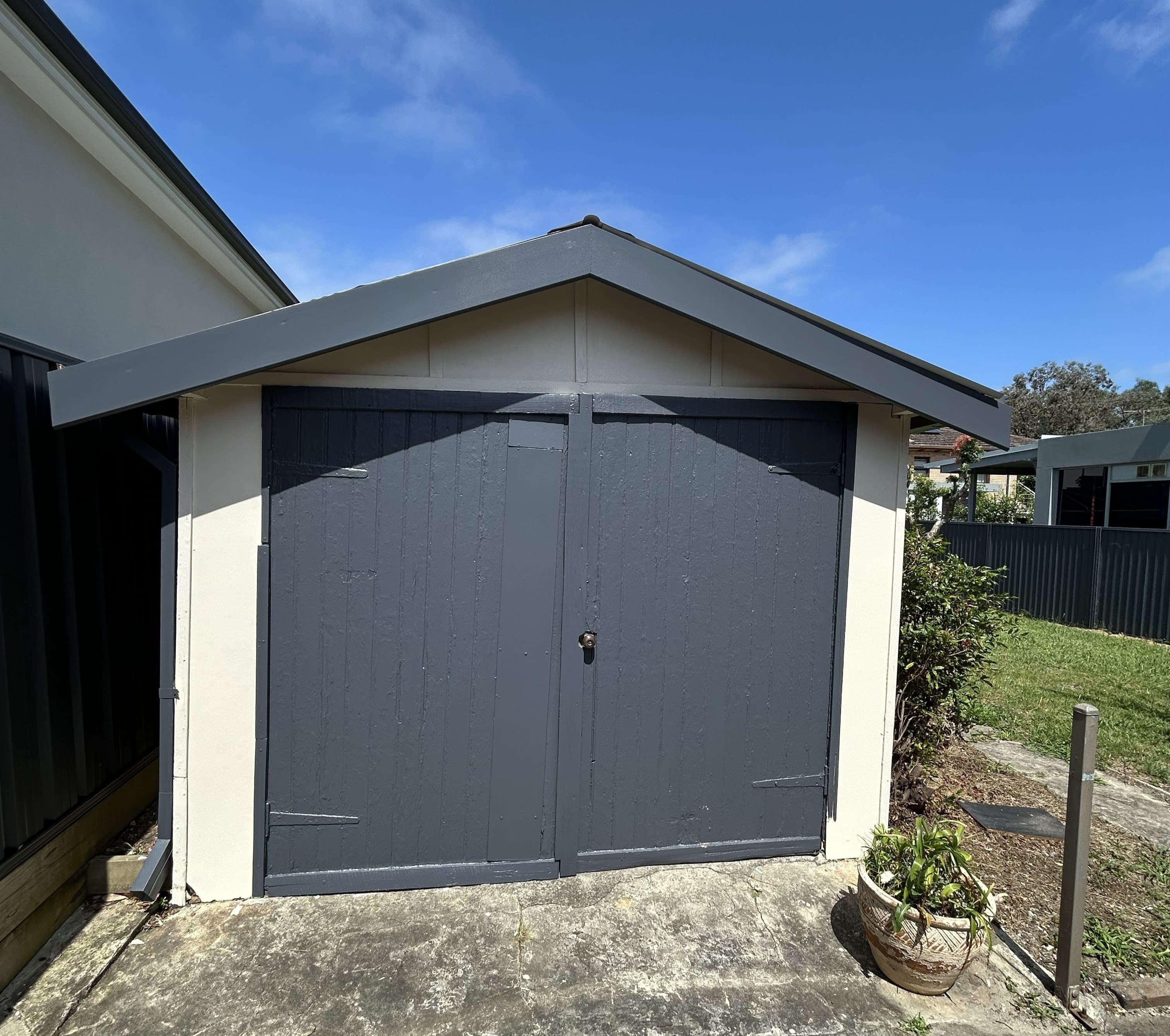 Exterior shed doors and trim after repainting in charcoal grey