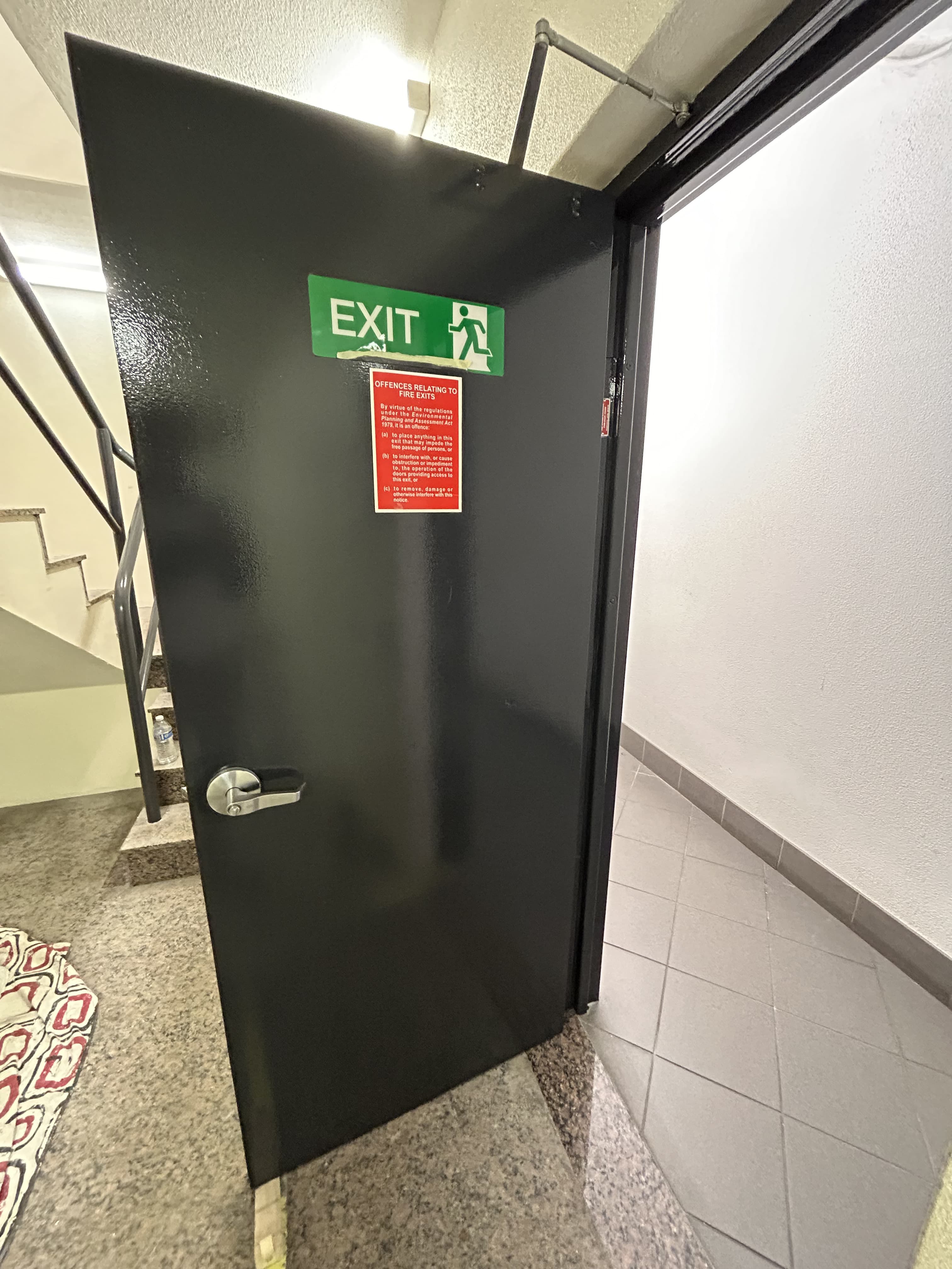 Commercial fire exit door after repainting in a black finish