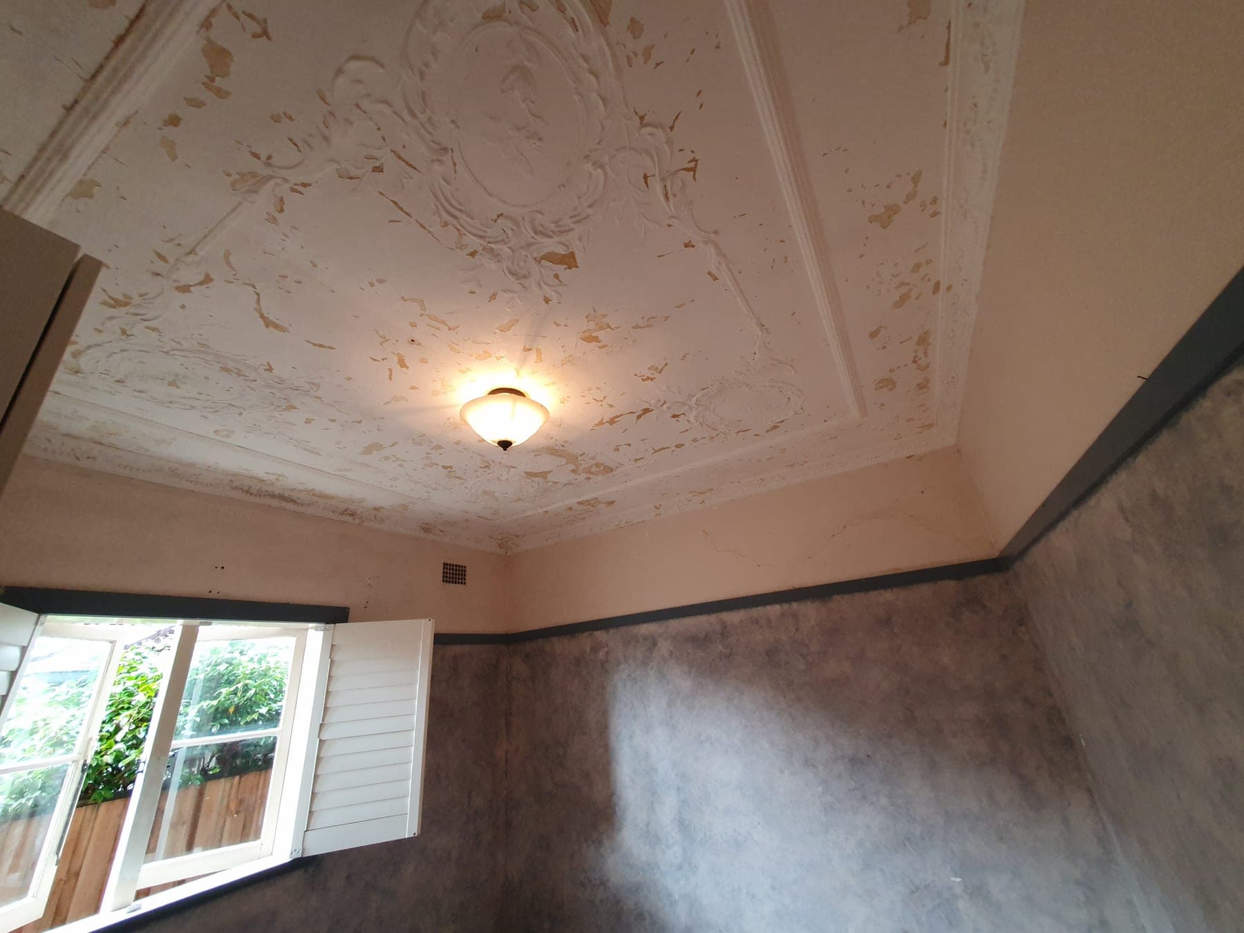 Roseville ornate ceiling before restoration with peeling paint and damaged coating