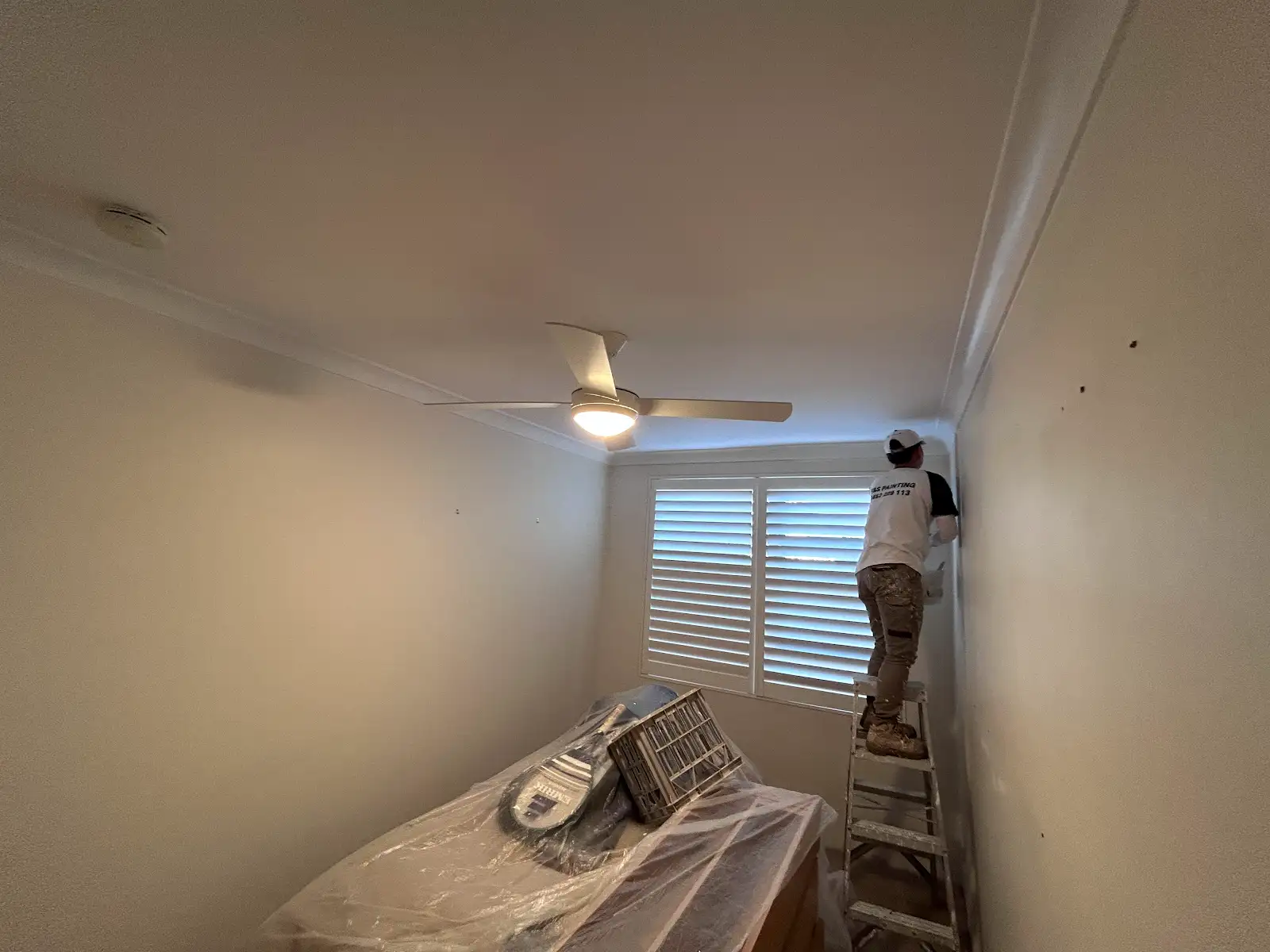 Painter completing detailed wall and ceiling preparation in a Chatswood apartment