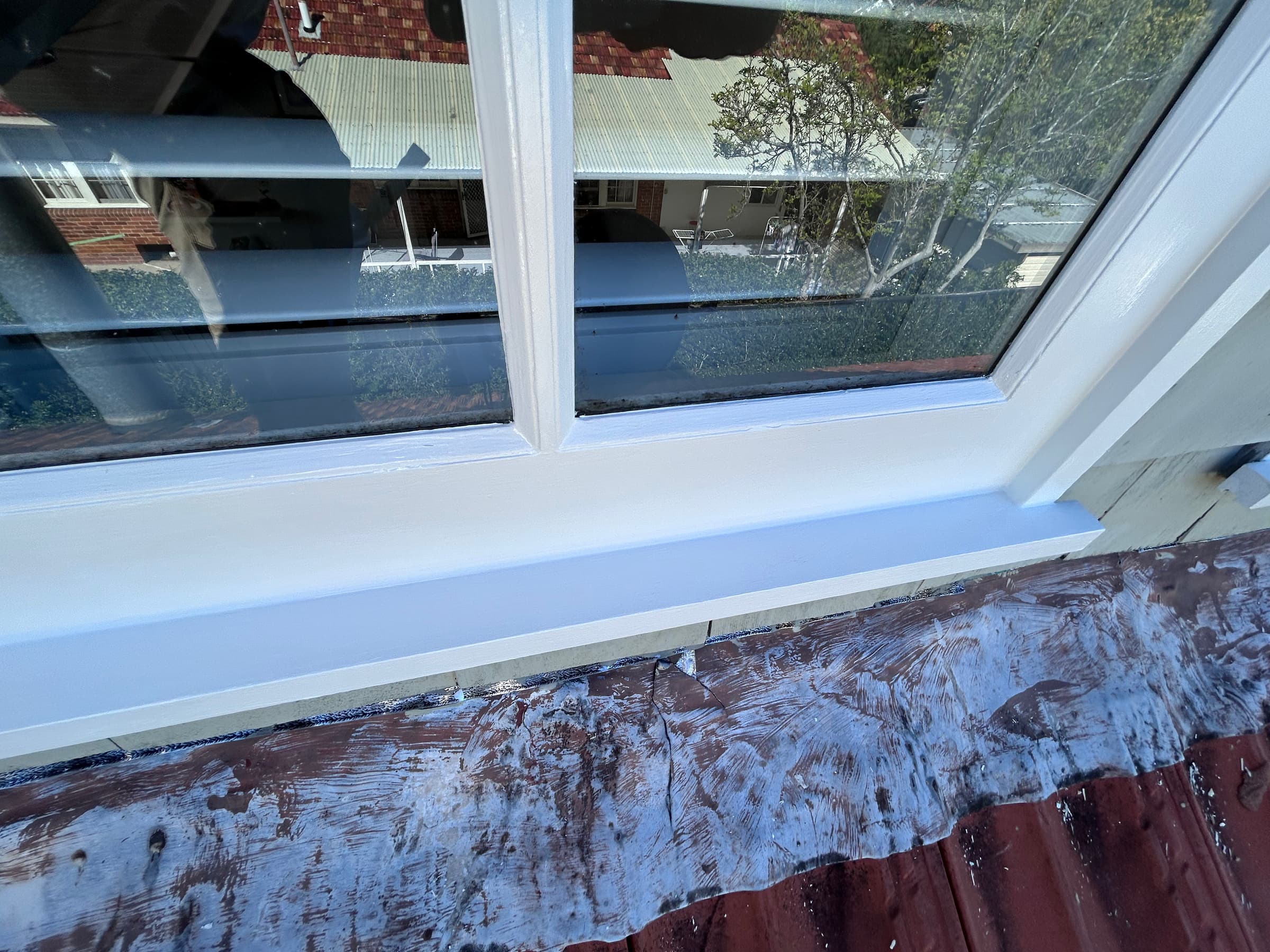 Close detail of a painted white timber window sill and frame in Chatswood